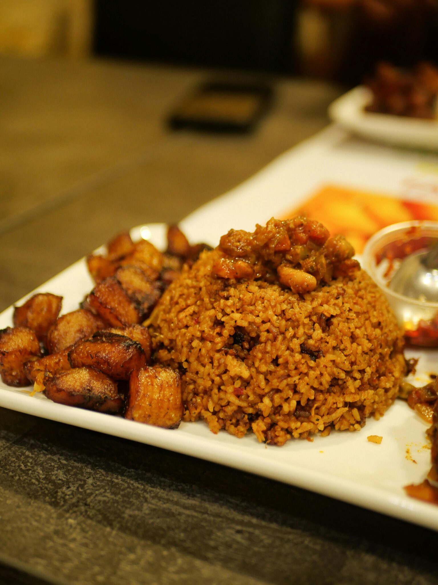 Close-up of West African Jollof rice with fried plantains, ideal for food lovers.